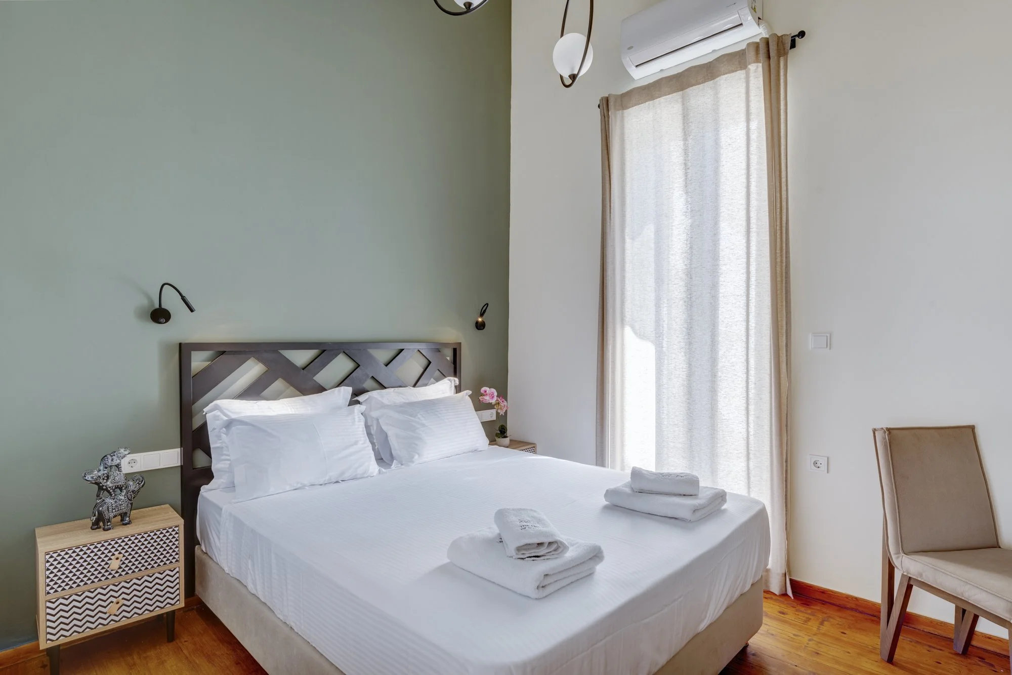 Bedroom one with white linen and its soft green wall
